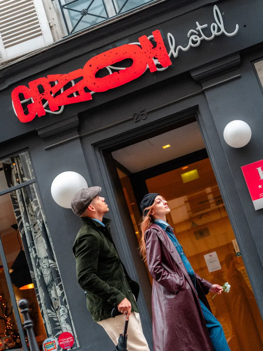 Facade and red neon sign of Hôtel Crayon at 25 rue du Bouloi, Paris 1st, near the Louvre