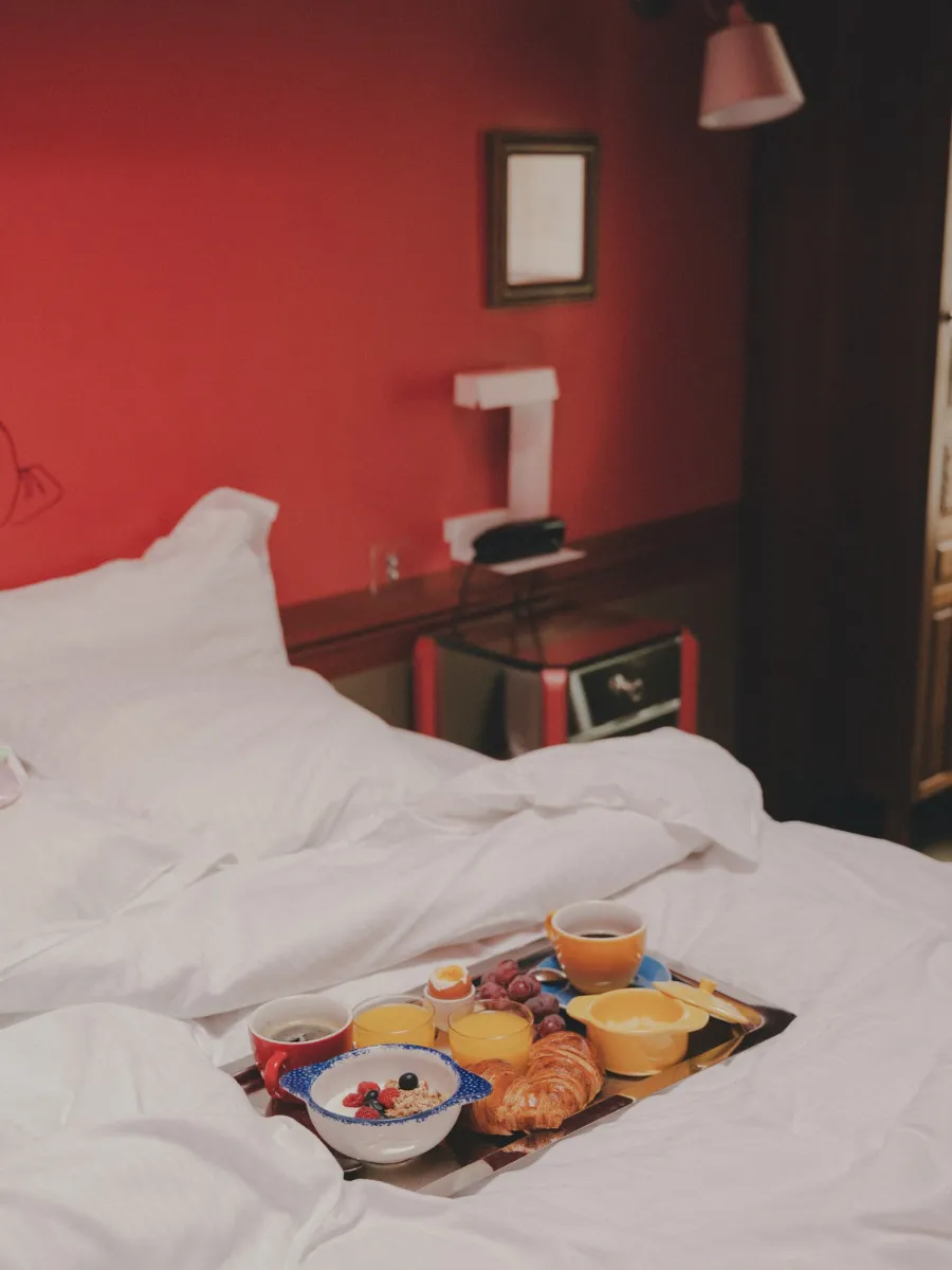 Continental breakfast served in bed in a red room, Crayon boutique hotel in Paris 1st arrondissement