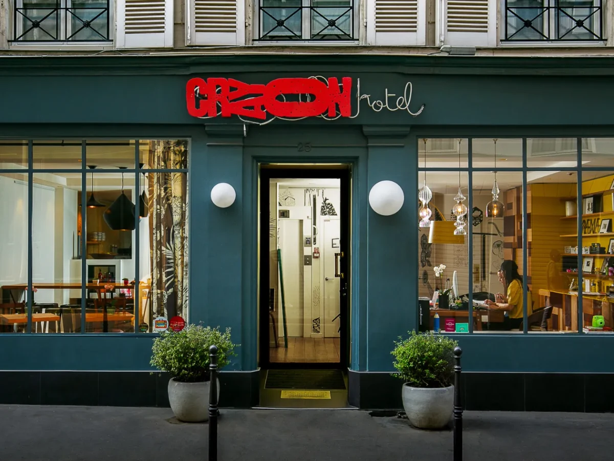 Devanture de l'Hôtel Crayon au 25 rue du Bouloi, Paris 1er : vitrines, enseigne néon et entrée fleurie