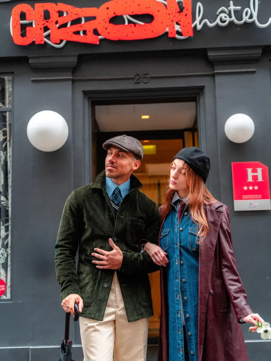 Couple sortant de l'Hôtel Crayon sous l'enseigne néon rouge, boutique-hôtel 3 étoiles à Paris 1er