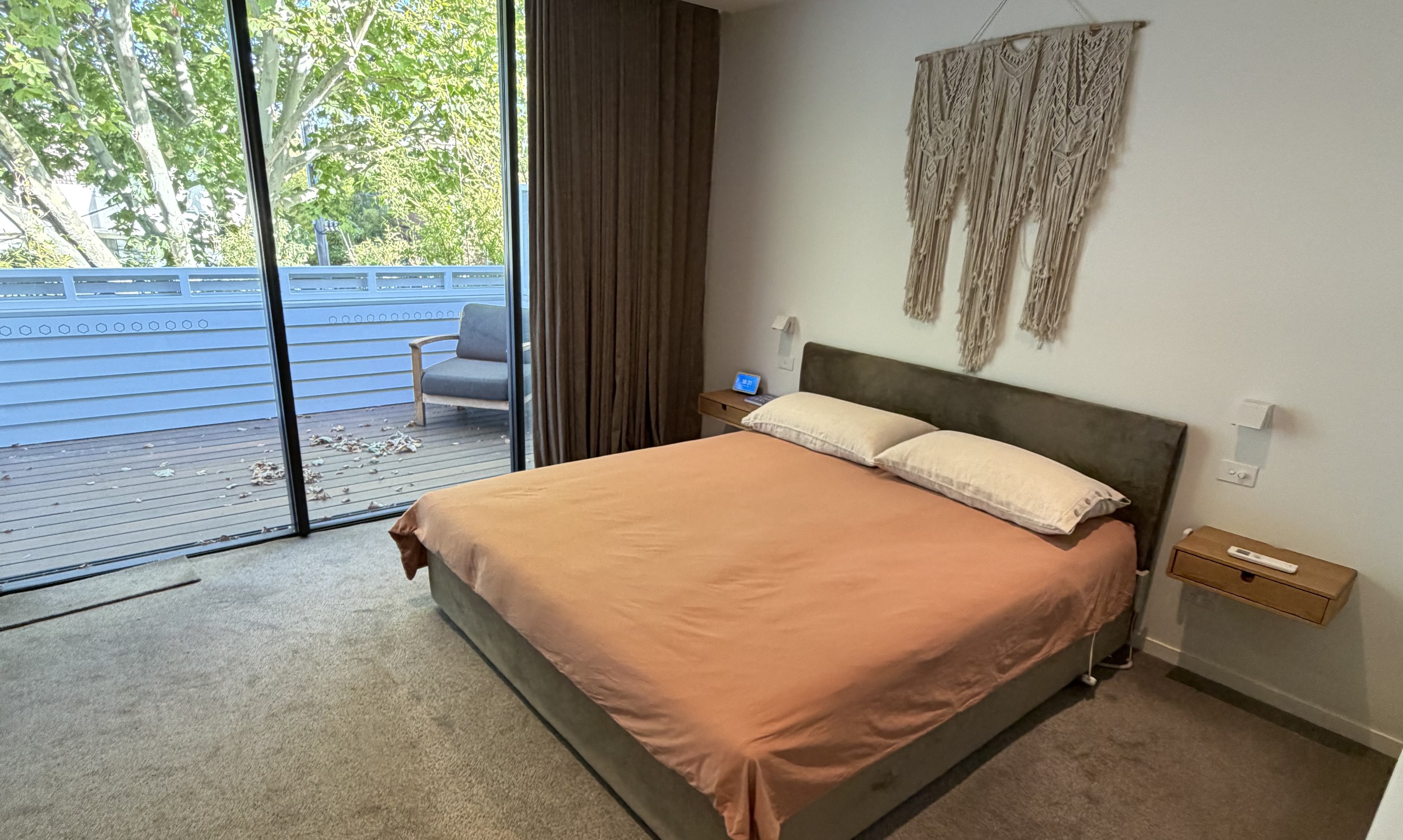 Bedroom opening to a timber deck and established trees