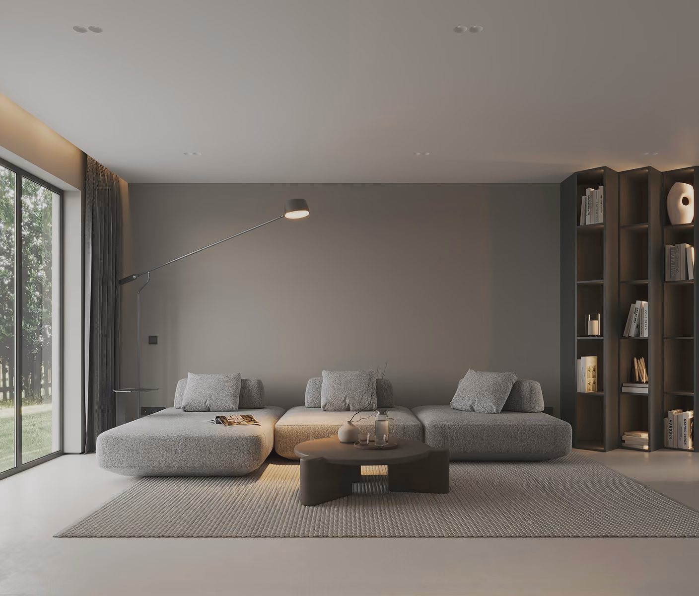 Minimalist living room with a gray modular sofa, round coffee table, floor lamp, and tall bookshelf.