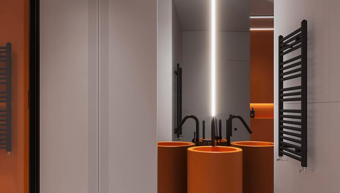 Modern bathroom with cylindrical orange sink, black faucet, large mirror, and black towel radiator.