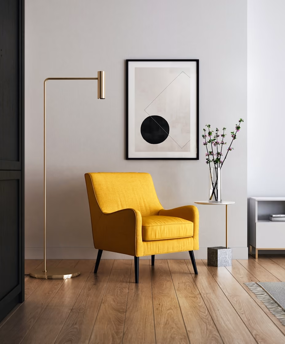 Yellow armchair by a gold floor lamp and small table with vase and flowers in a modern living space.