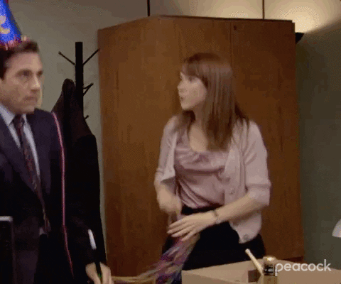 Scene from The Office showing Michael Scott and Erin Hannon wearing party hats in an office setting with a desk and coat rack.