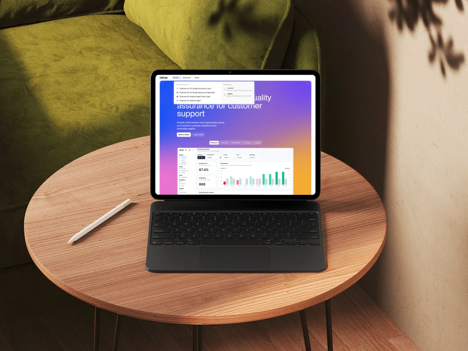 Tablet with keyboard and stylus on a wooden round table, displaying a customer support quality assurance dashboard.
