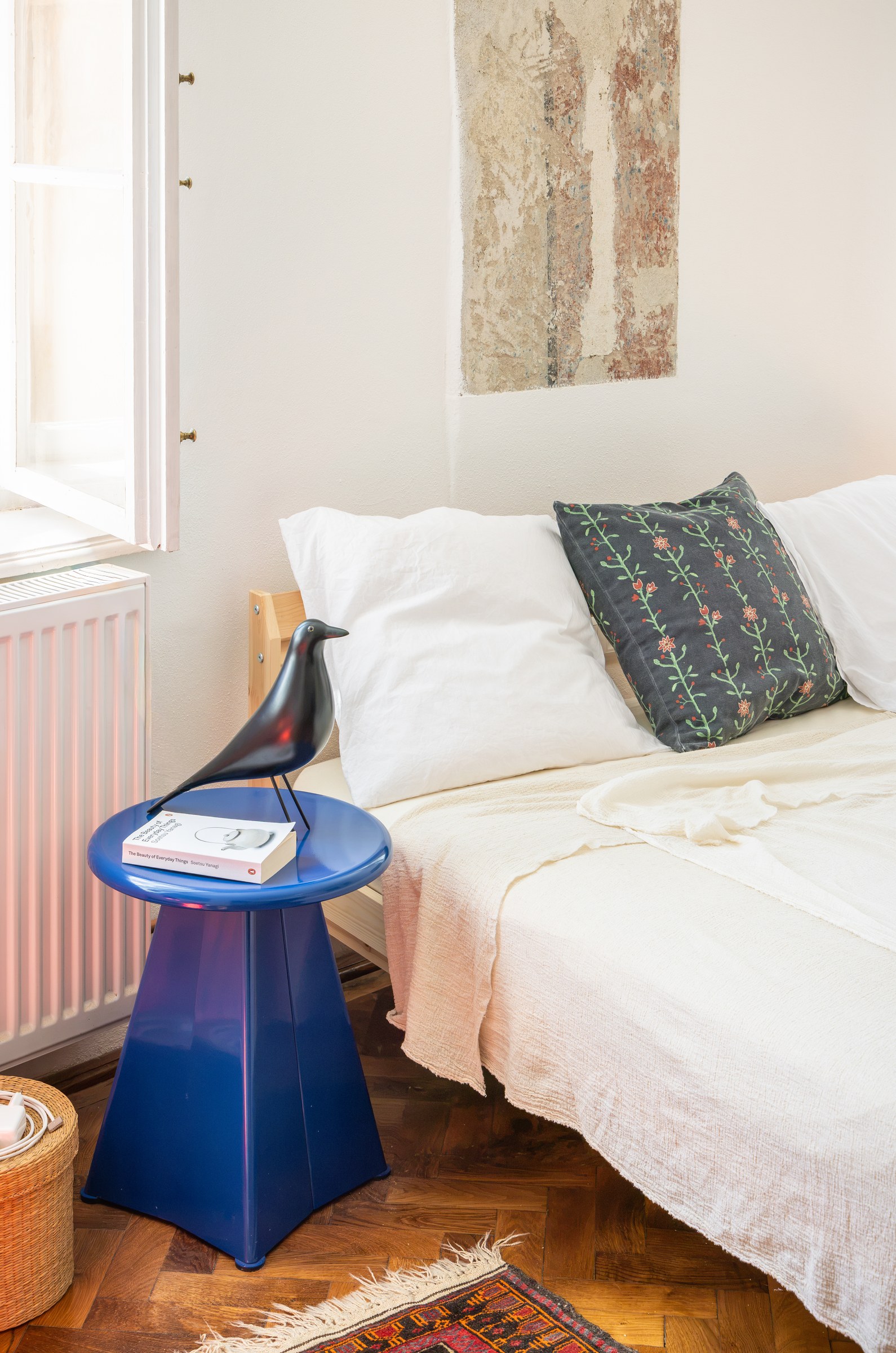 Blue Vitra side table beside the bed in a Sibiu apartment