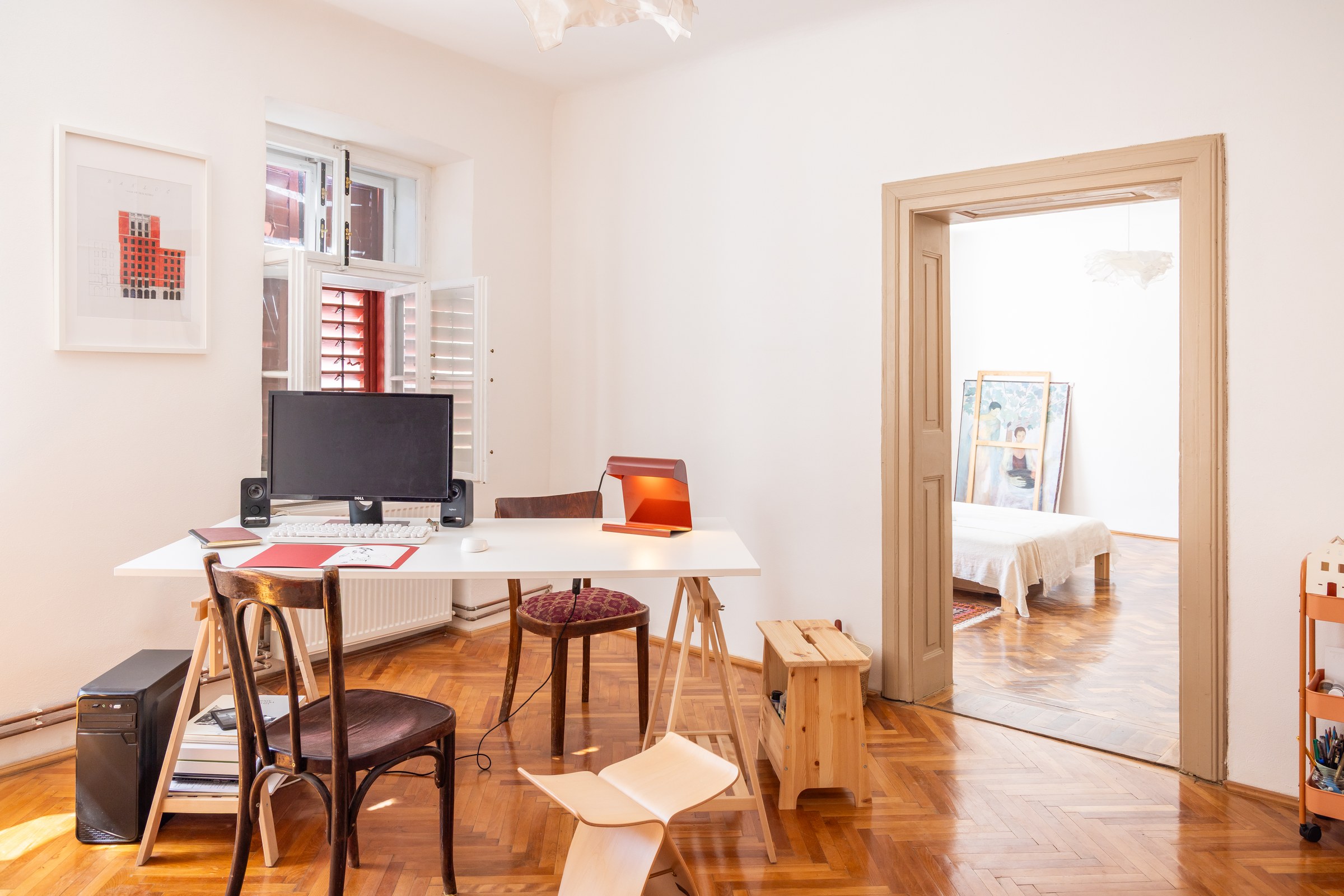 Bright apartment workspace with a desk, chairs and shelves