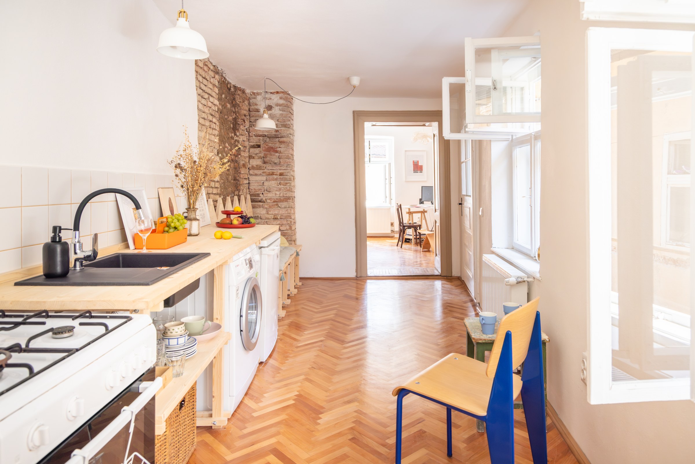 Bright kitchen with seating, exposed brickwork and pendant lighting