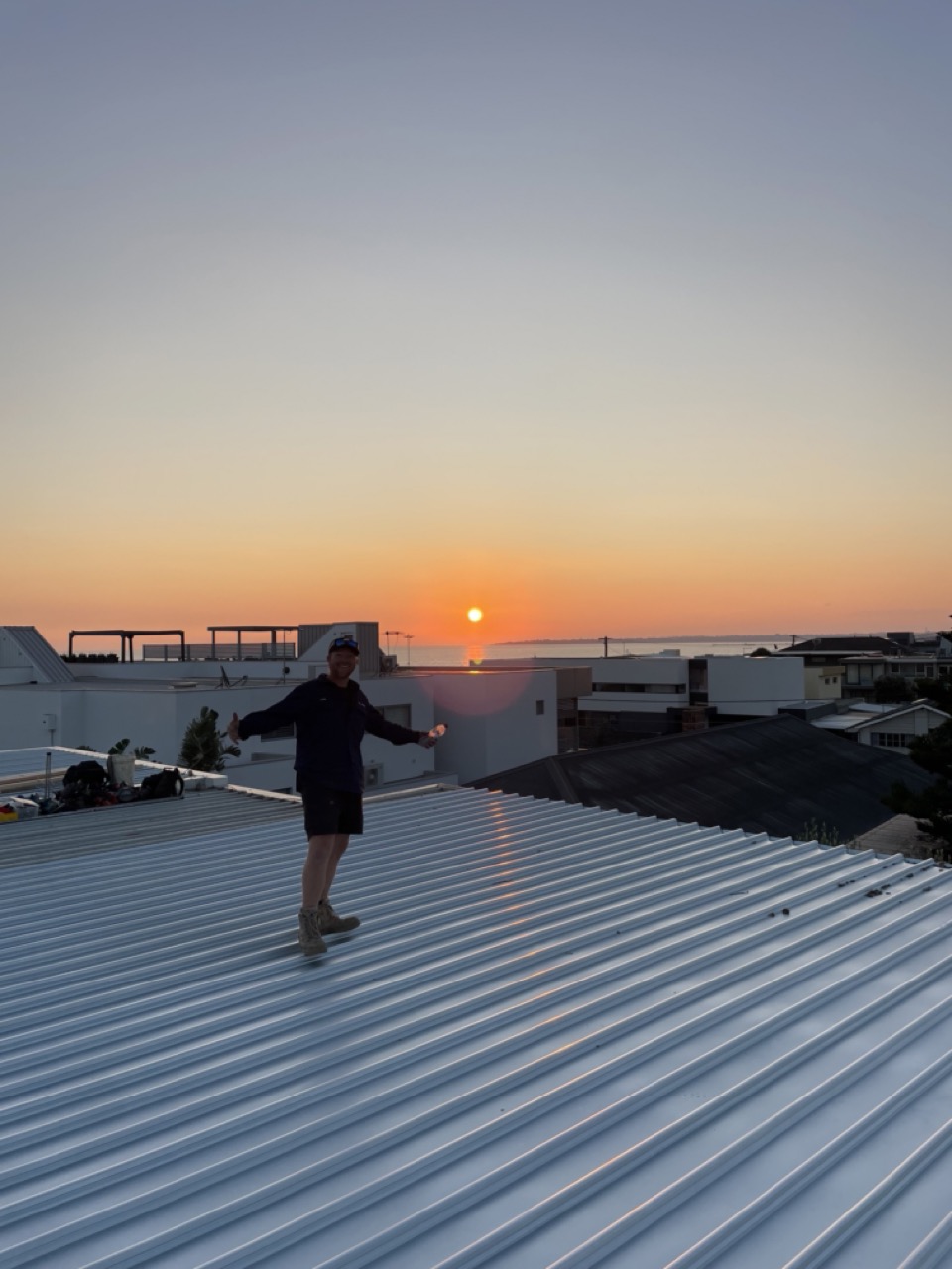 Roof plumbing job finishing at sunset