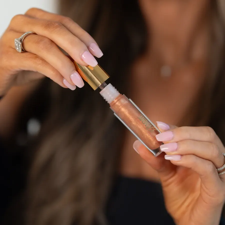 Hands opening a Gemme lip gloss tube