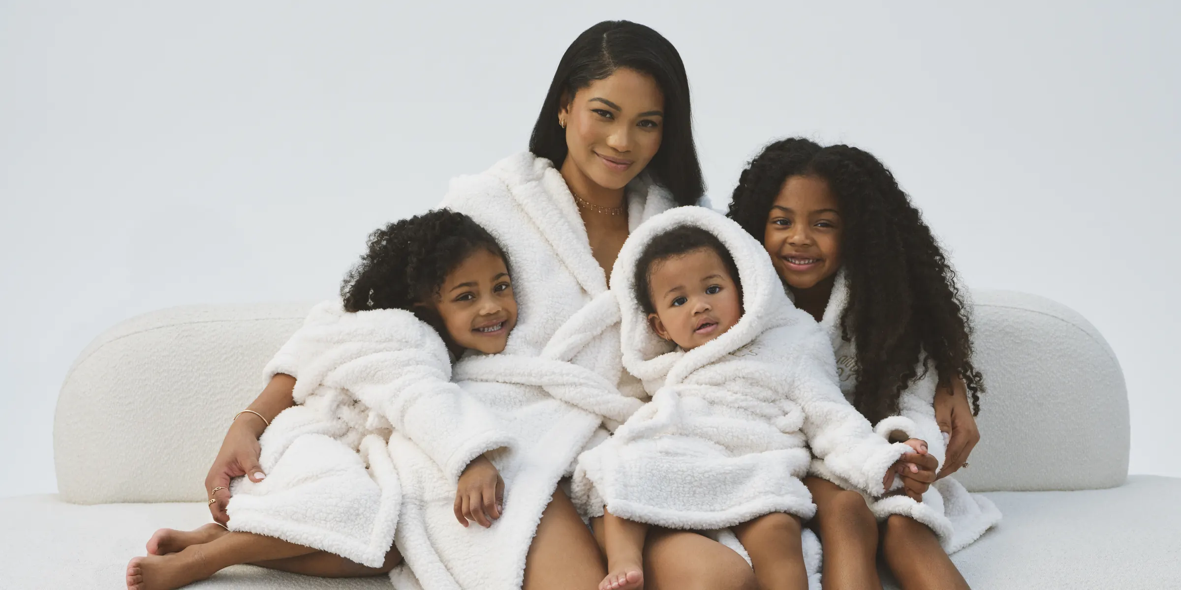 A family in white Chasa robes on a sofa