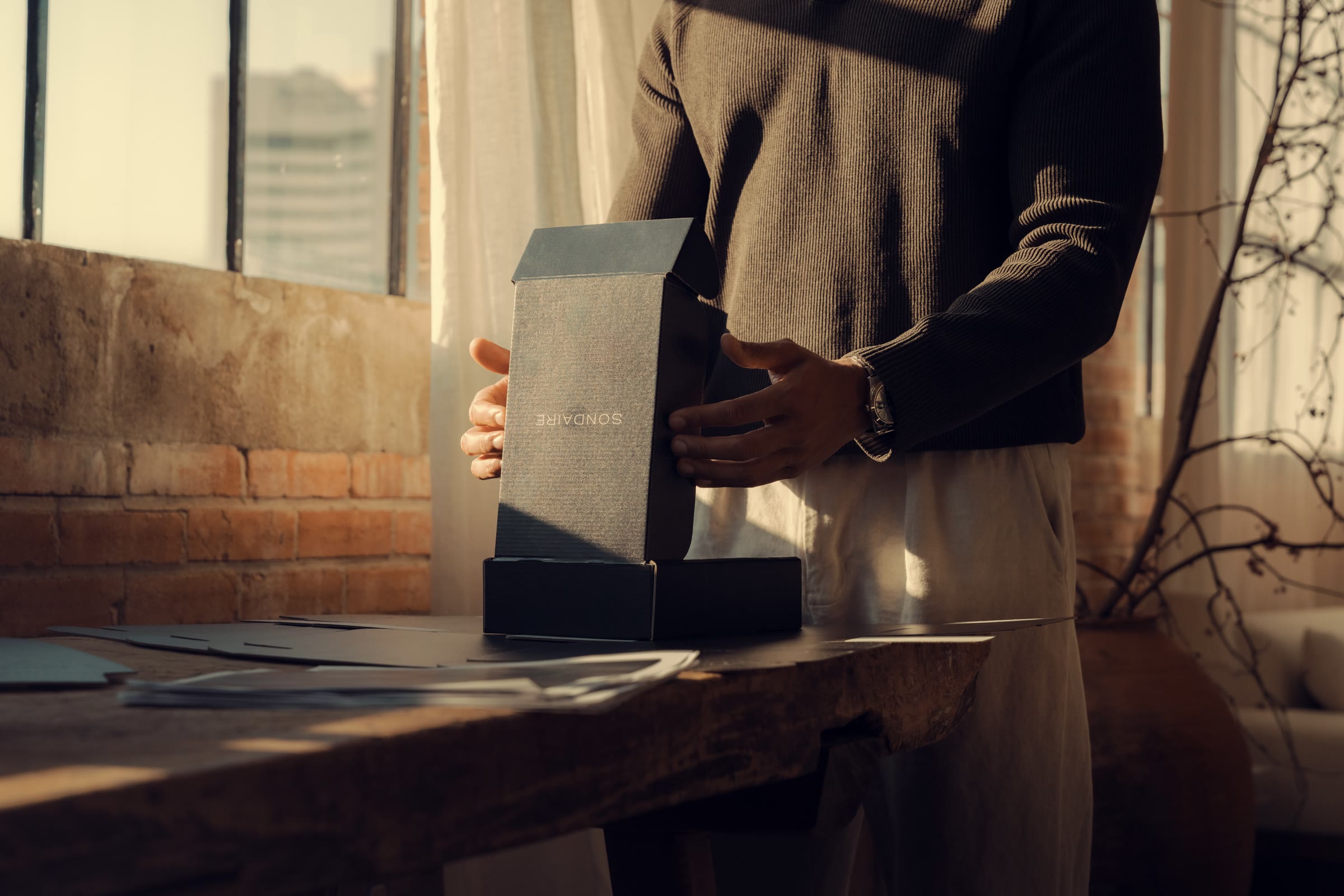 Hands holding a Sondaire box in a sunlit studio