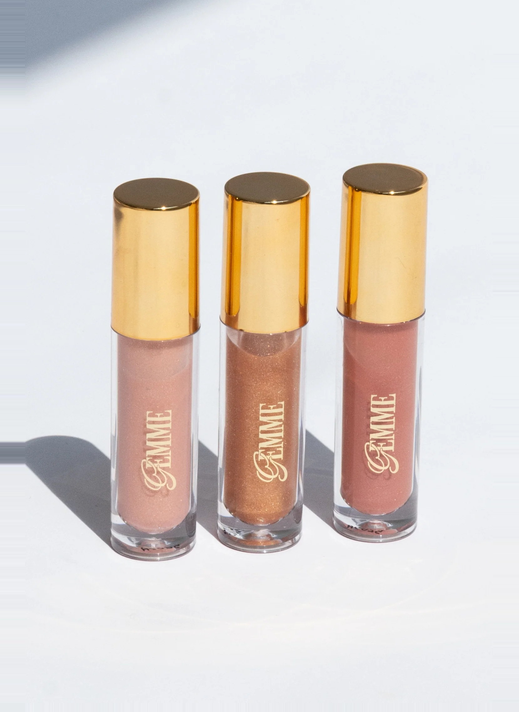 Three Gemme lip toppers lined up on a white surface
