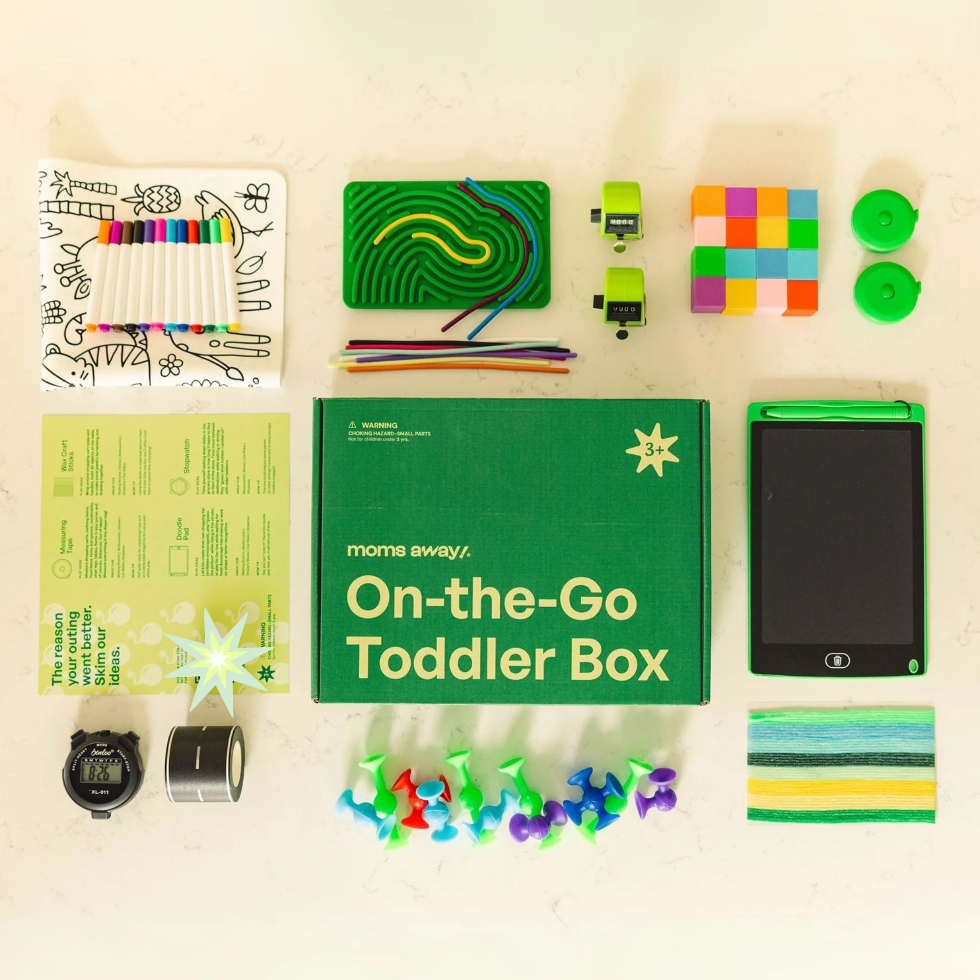 The Moms Away! On-The-Go Toddler Box laid out with its activities and accessories