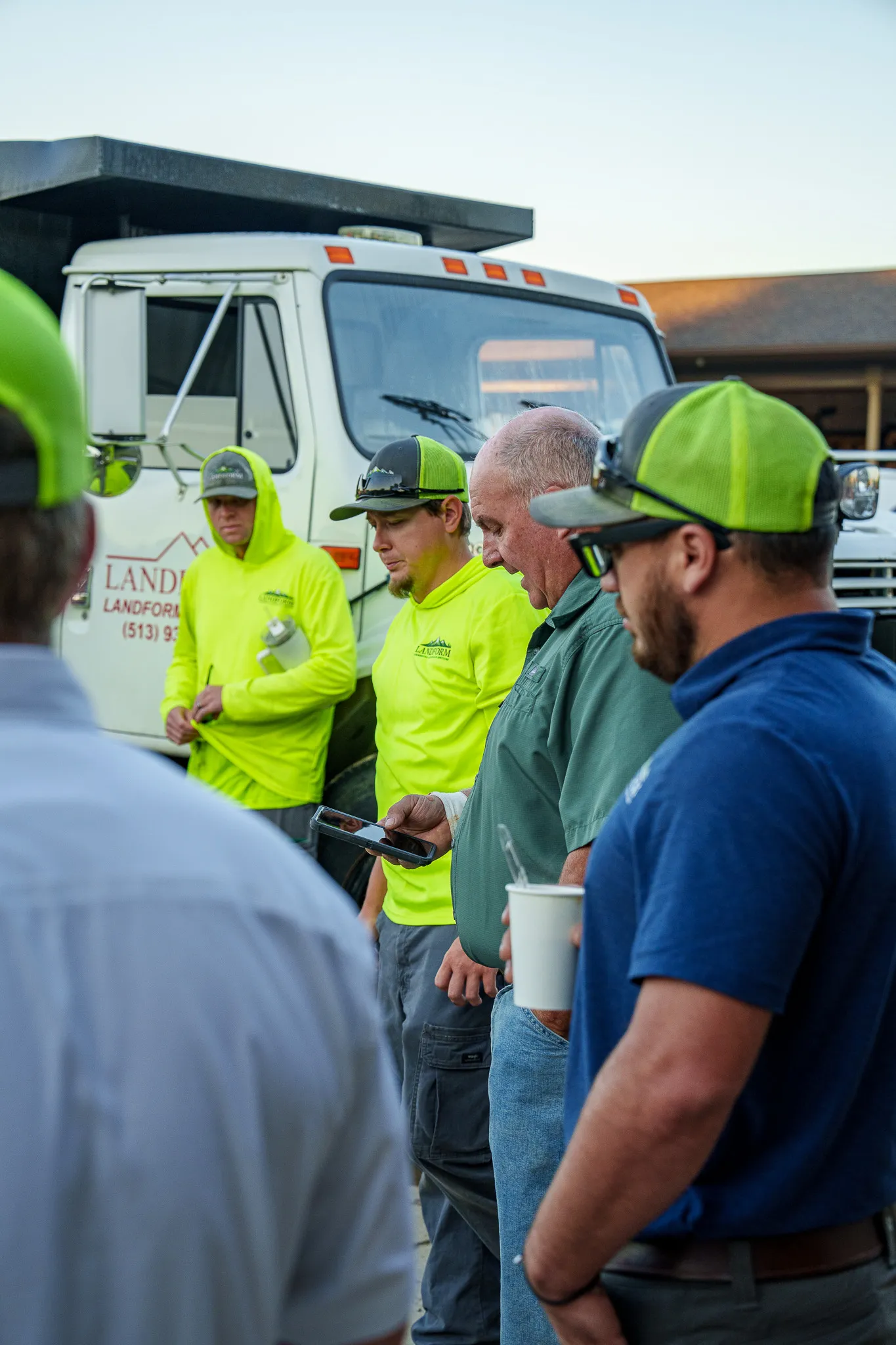 Landform team members talking together at the start of the day, coffee in hand