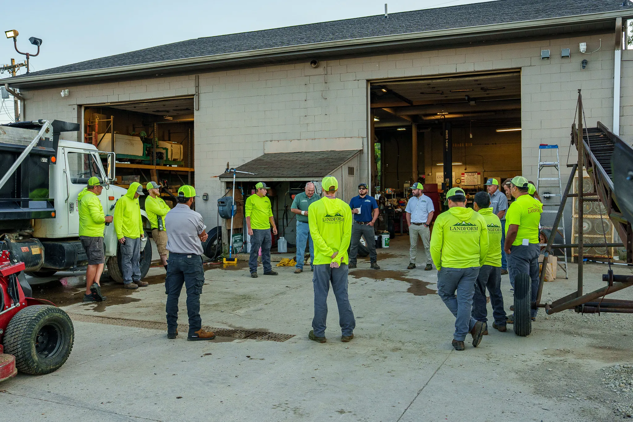 The Landform crew gathered in a circle outside the shop for the morning huddle