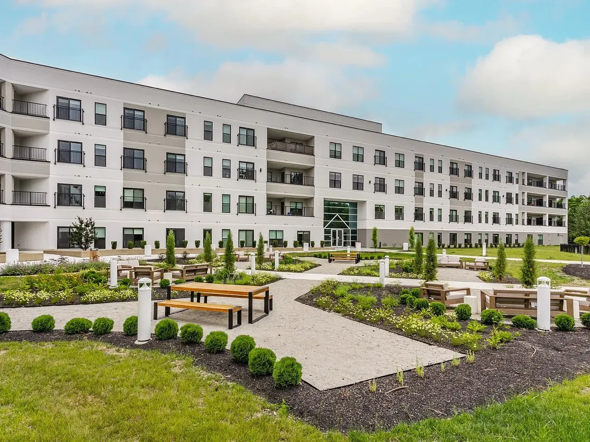 Apartment community with landscaped courtyard, walkways, and trimmed shrub beds