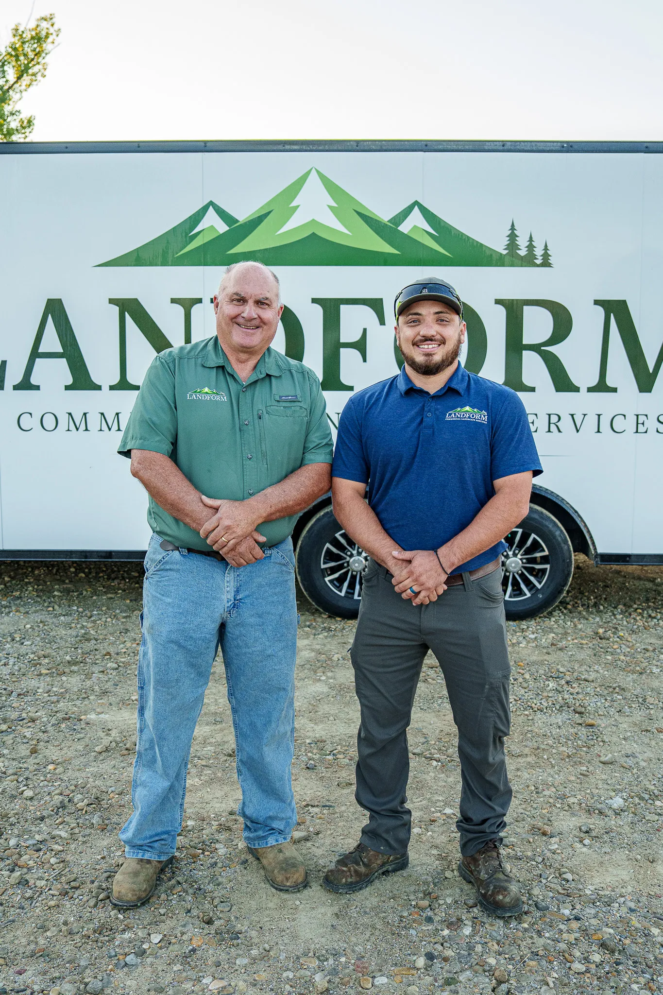 Two Landform team members standing together in front of the branded company trailer