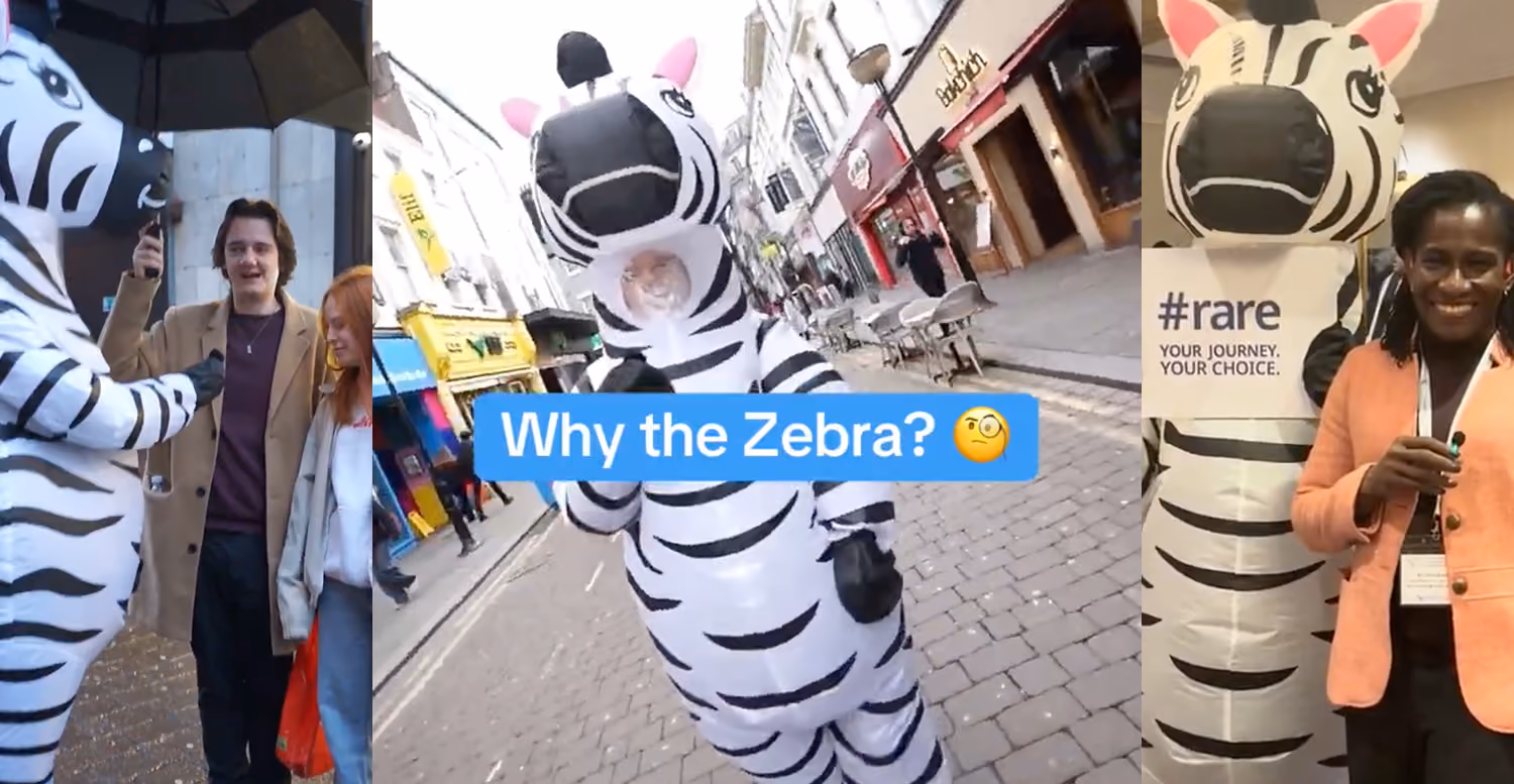 Three photos showing a person in a zebra costume interacting with people on city streets, one photo with the text 'Why the Zebra?' and a thinking face emoji, and another photo featuring a woman standing next to the zebra mascot holding a pen with a sign that reads '#rare YOUR JOURNEY. YOUR CHOICE.'