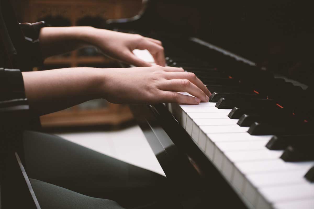 hands playing a piano