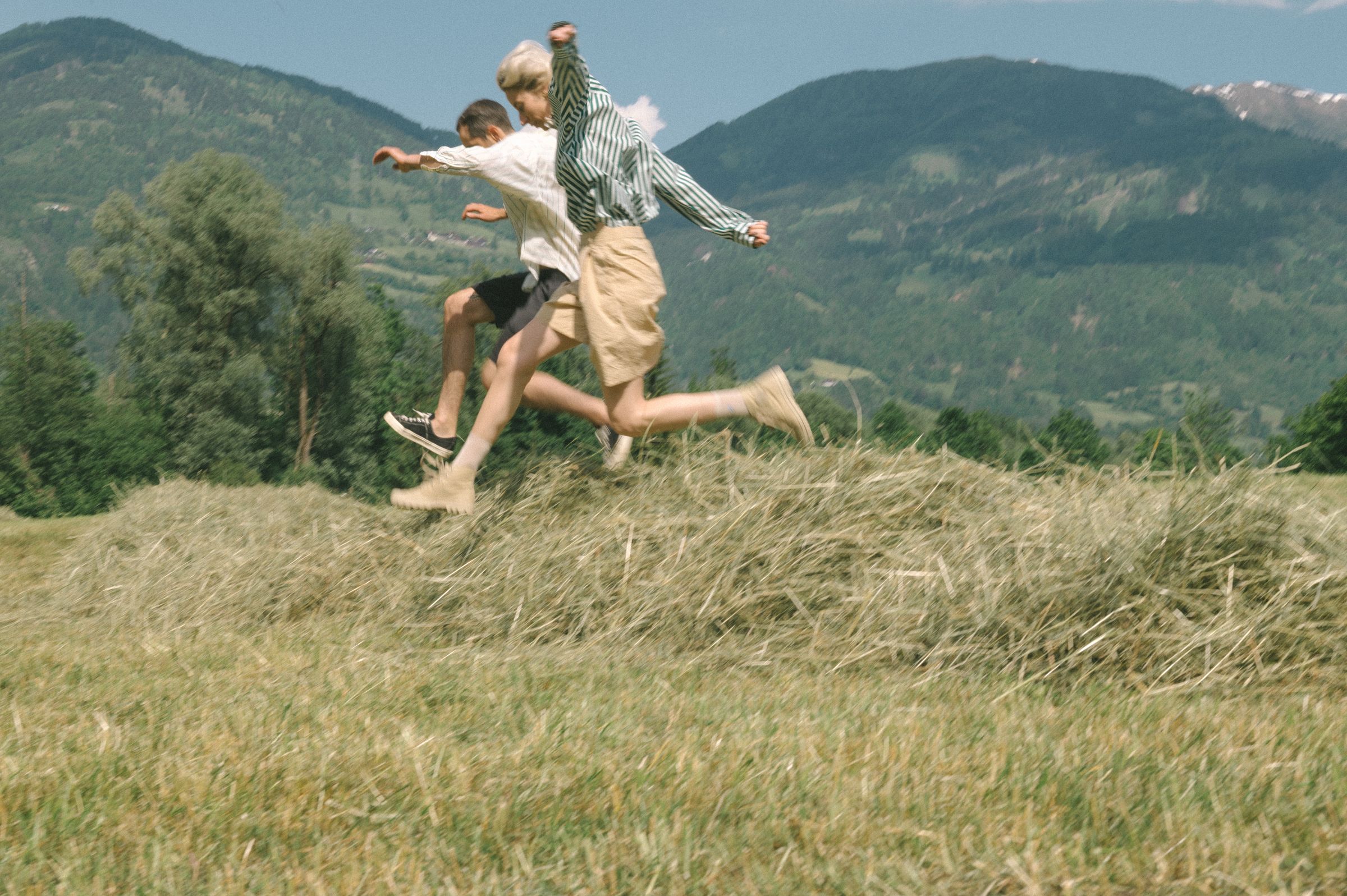 A figure leaping through long grass in open countryside