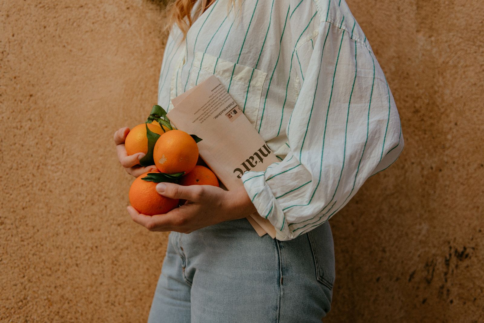 Someone holding an armful of fresh oranges