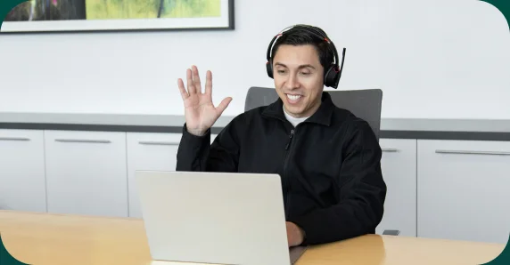 IT support engineer with a headset waving on a video call