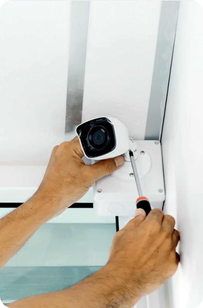 Engineer installing a CCTV camera on an office wall