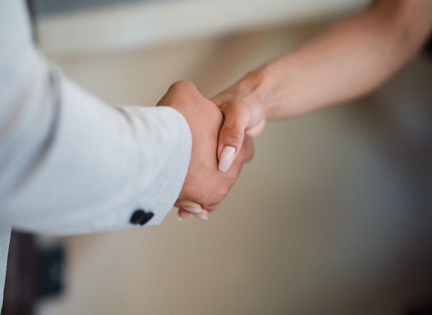 Two people shaking hands to agree a contract buyout