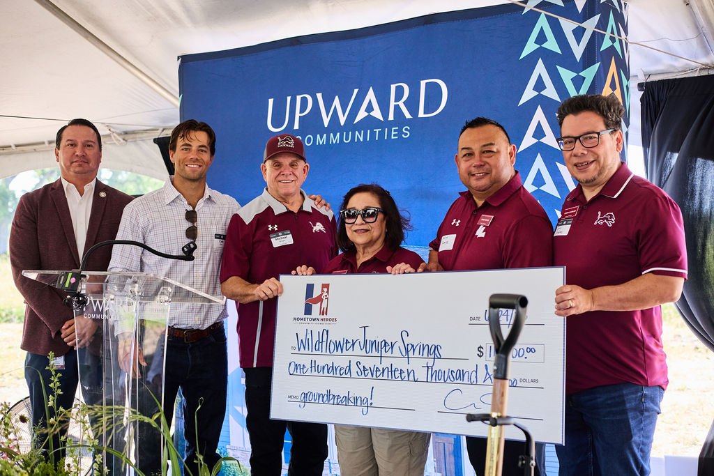 Hometown Heroes Community Foundation and Lockhart ISD leaders with an oversized check at the Wildflower Juniper Springs groundbreaking