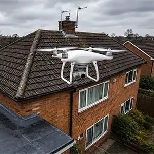 Drone inspecting residential roof tiles from above