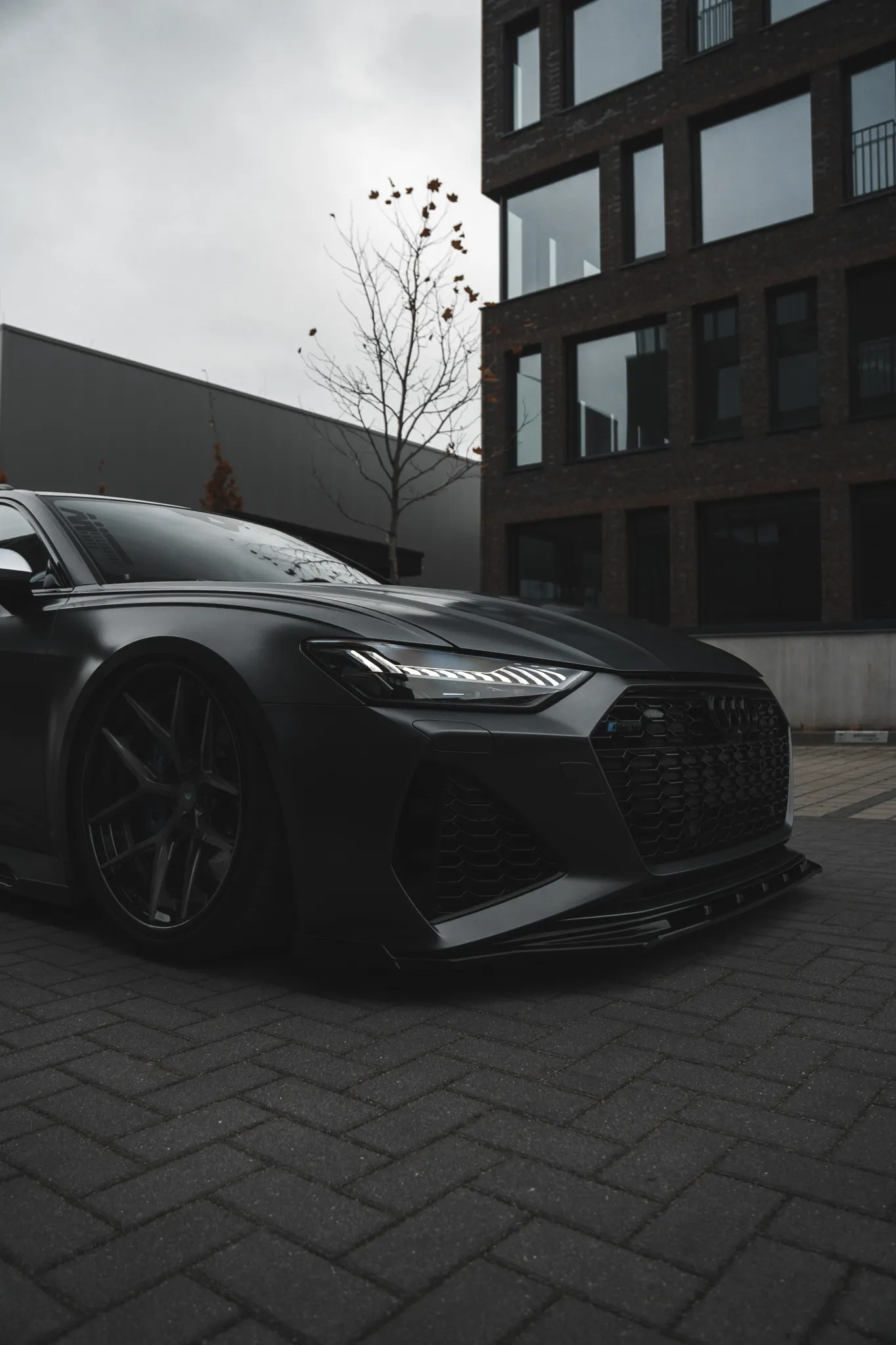 Black sedan parked on a brick street