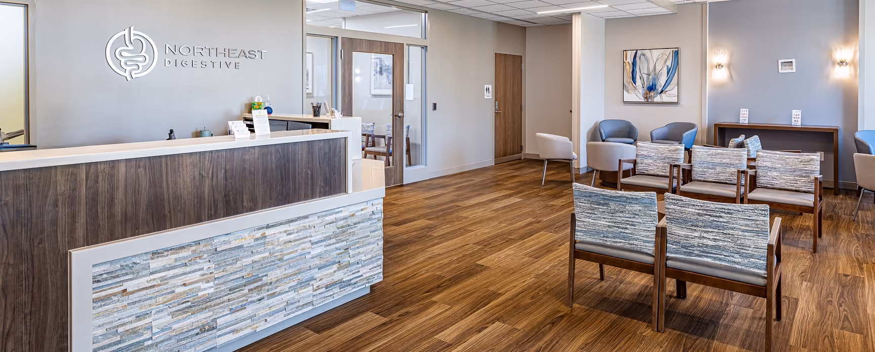 Northeast Digestive's front lobby with reception desk, stone accent wall and patient waiting area.