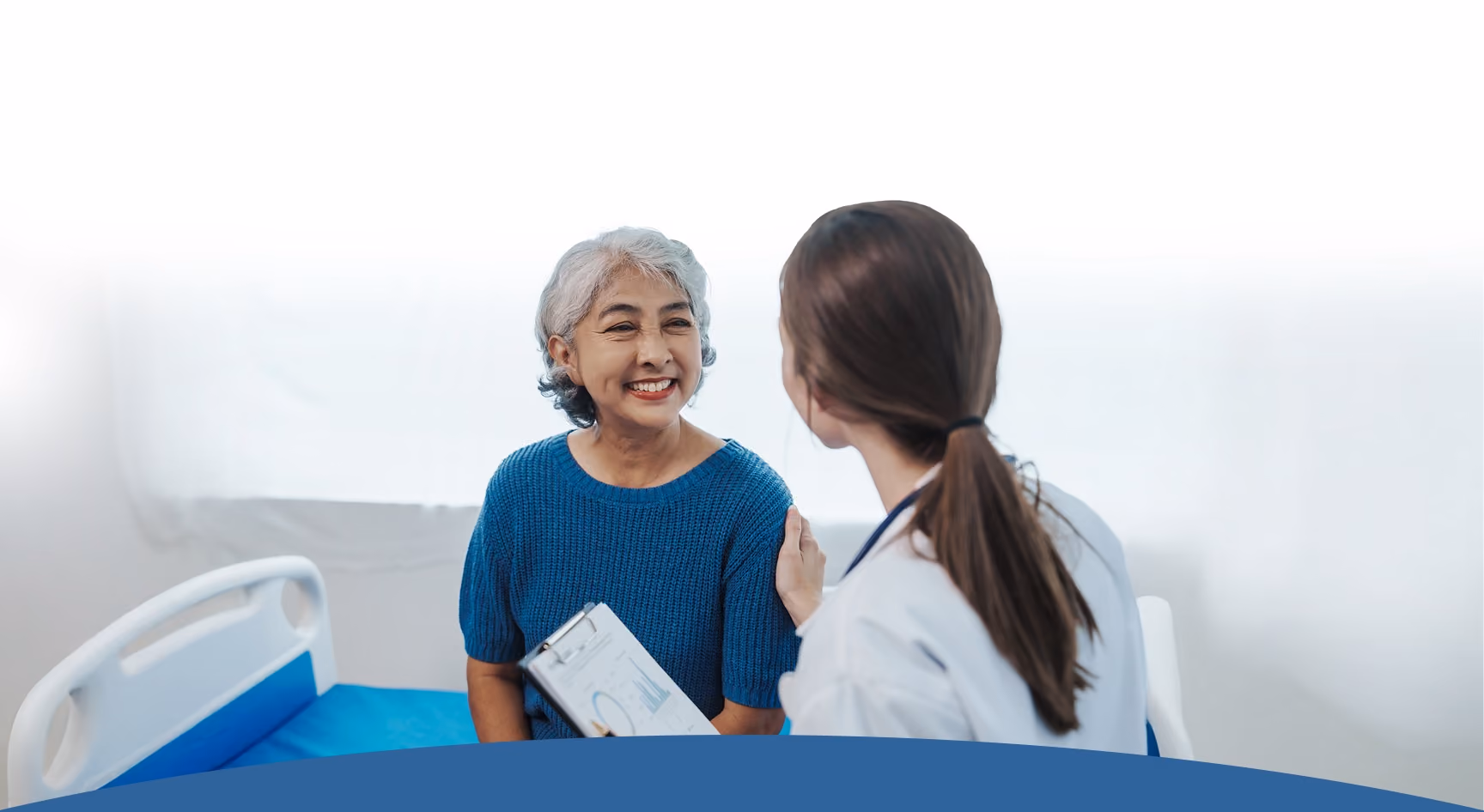 A Northeast Digestive gastroenterologist smiling with a senior patient during a compassionate consultation.