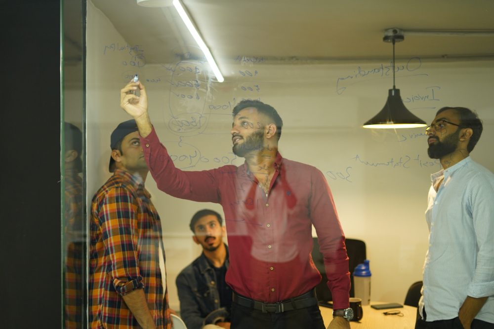 Working through a problem at the glass whiteboard