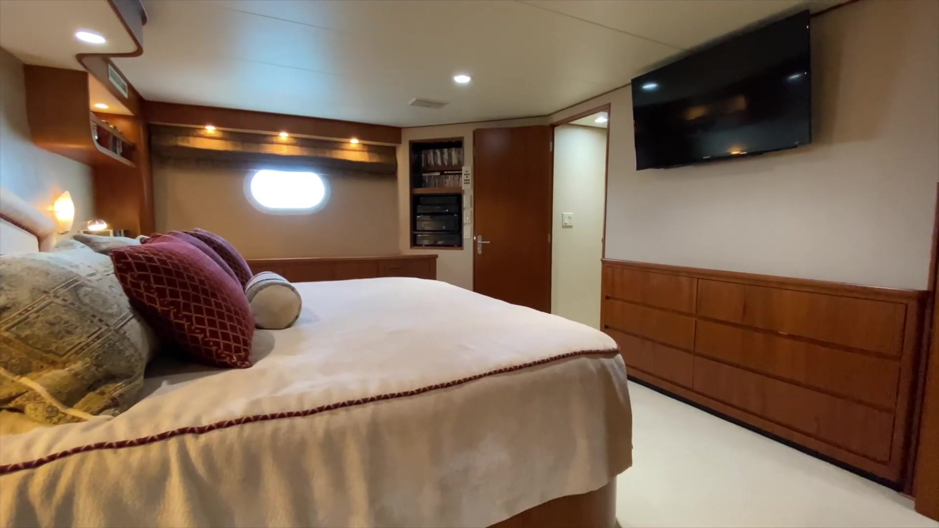 Stateroom with a bed, cabinets and a porthole