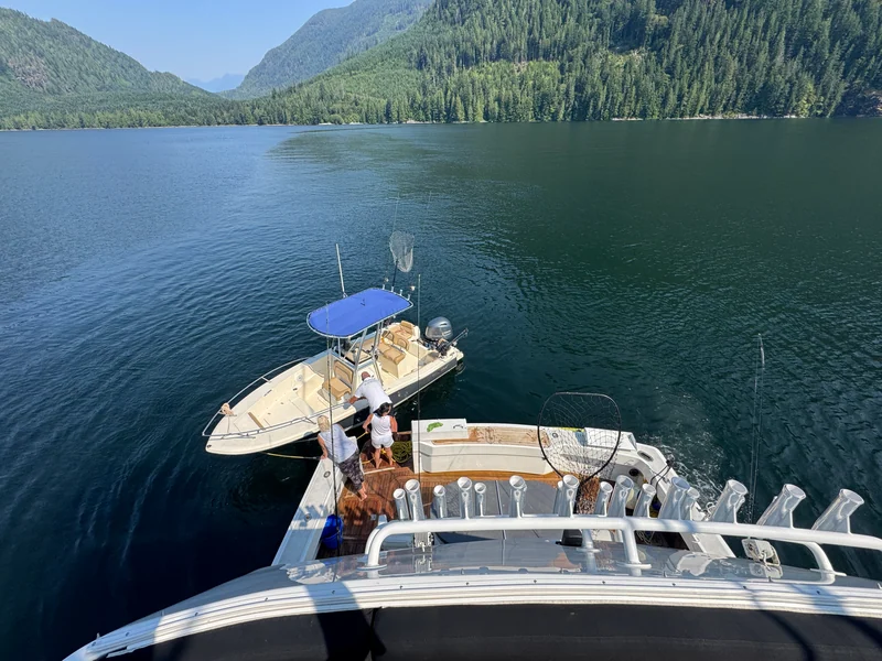 View from Surfrider's upper deck toward the cockpit and a center-console boat alongside.