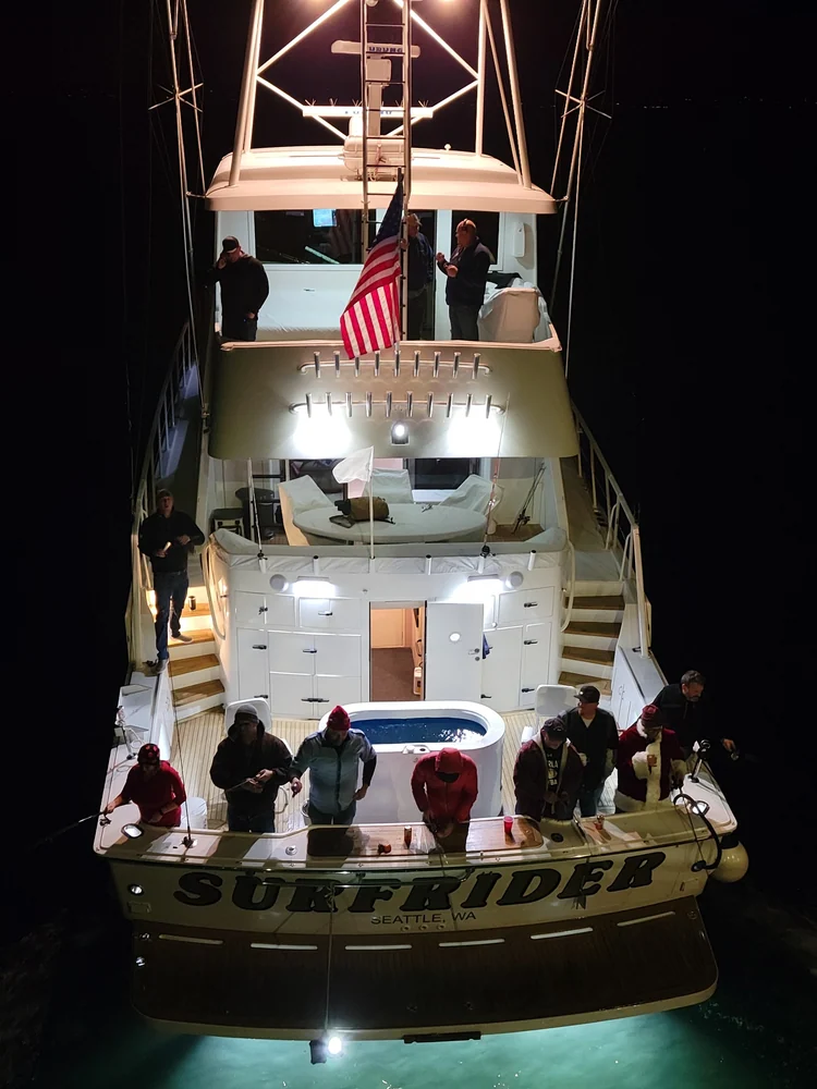People gathered at Surfrider's illuminated stern after dark.