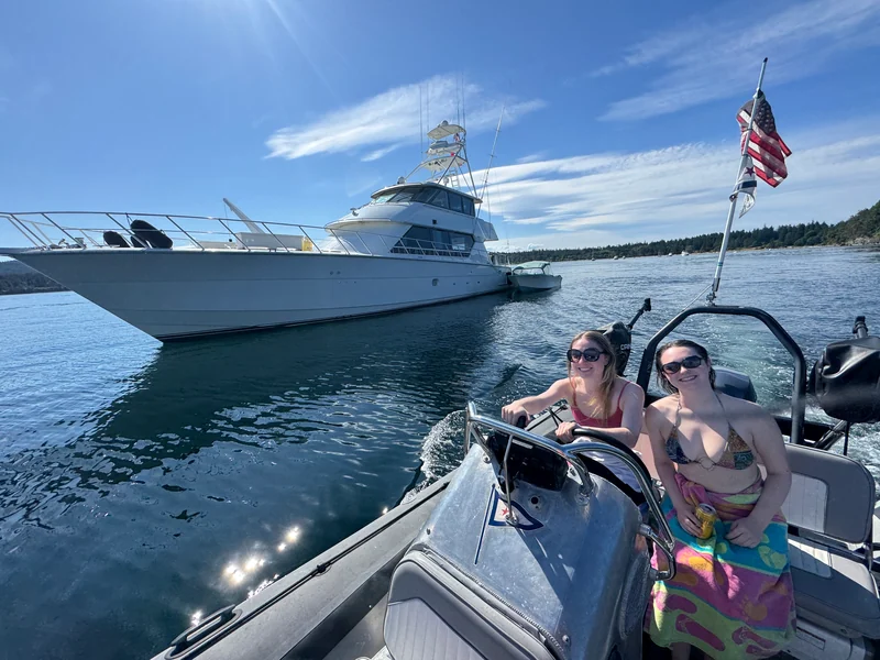 Two people on a personal watercraft with Surfrider in the background.
