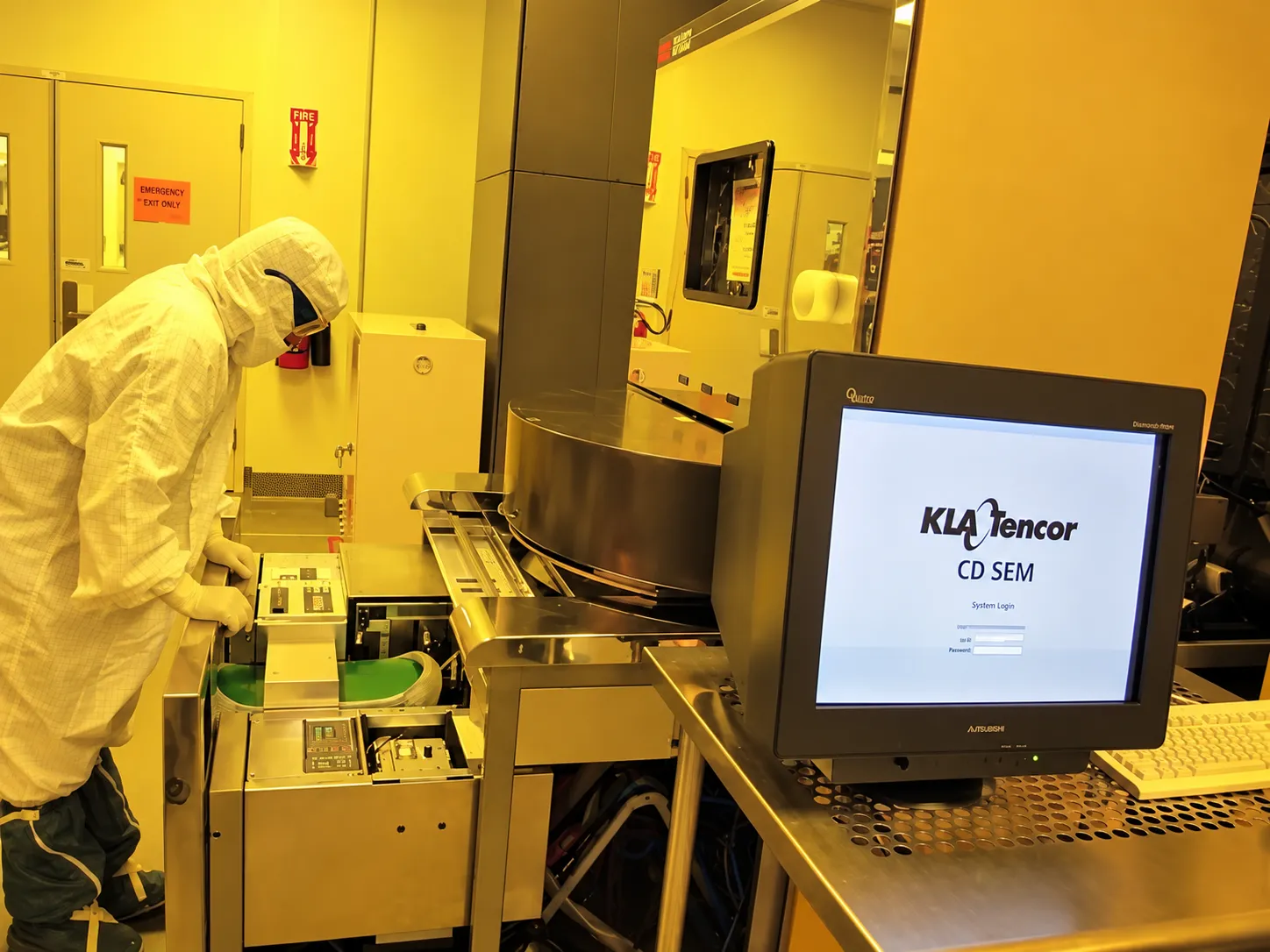 GCE engineer inspecting a wafer under a microscope in a cleanroom