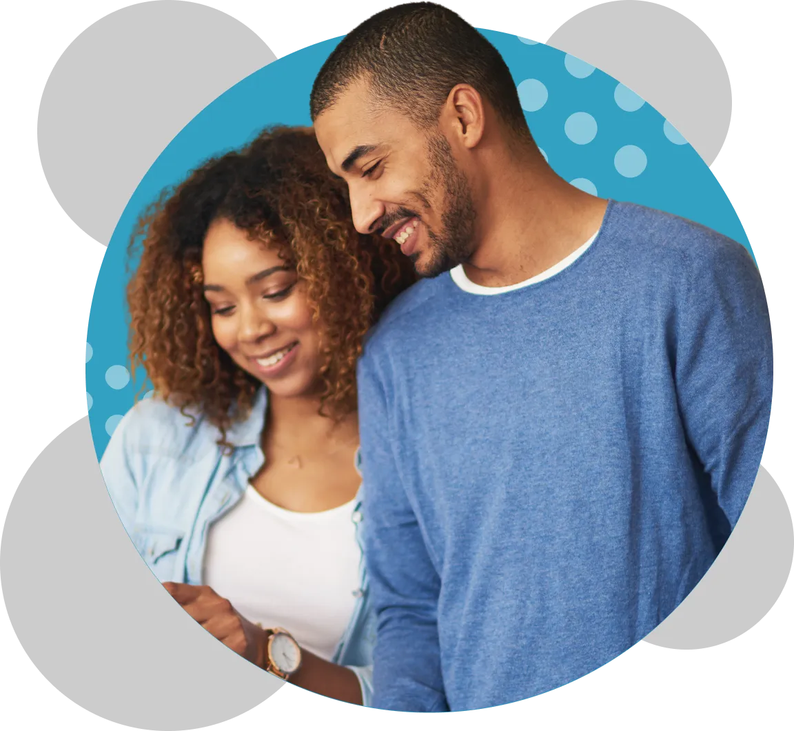 Smiling young man and woman looking at a smartphone together, inside a blue circular frame with light blue polka dots and gray overlapping circles around it.