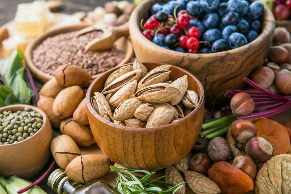 An assortment of berries, nuts, seeds, and greens