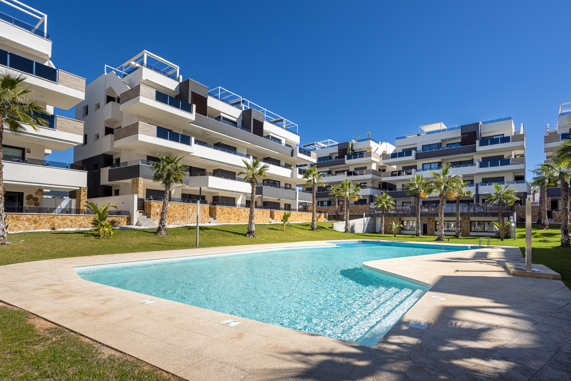 Gemeenschappelijk zwembad en tuinen tussen de moderne appartementenblokken van Amanecer XI, Orihuela Costa, de thuisbasis van Casa 504