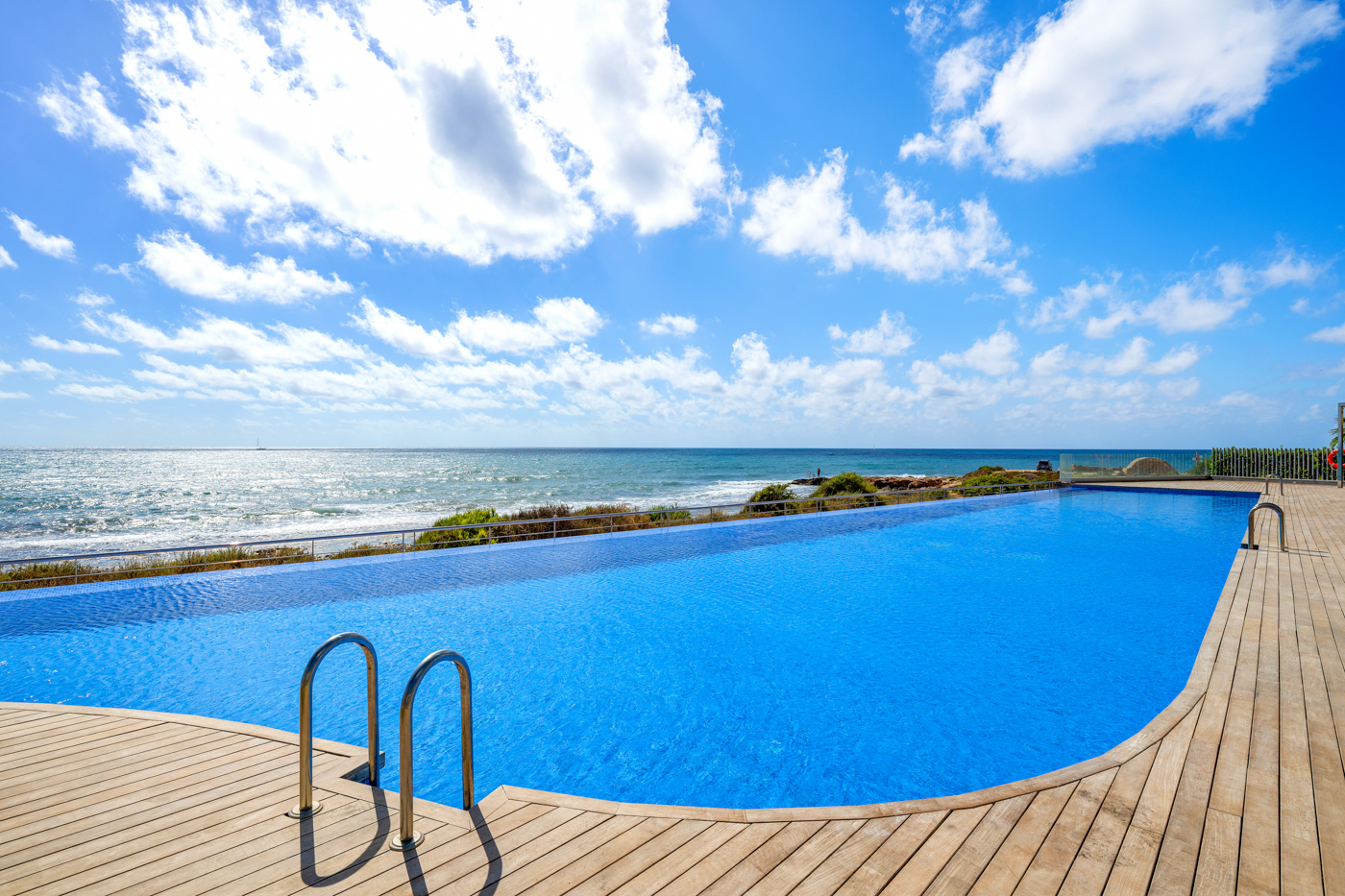 Infinity pool op een houten terras met uitzicht op zee bij Residencial Posidonia, Torrevieja, de thuisbasis van Casa Memo