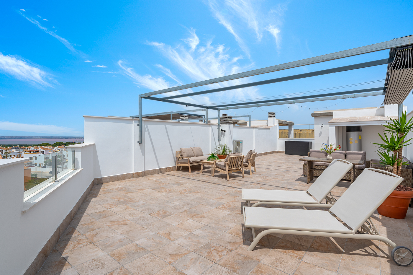 Zonnig terras van Casa H2 met pergola, ligbedden en zitgedeelte buiten bij Sunset Hill, Orihuela Costa