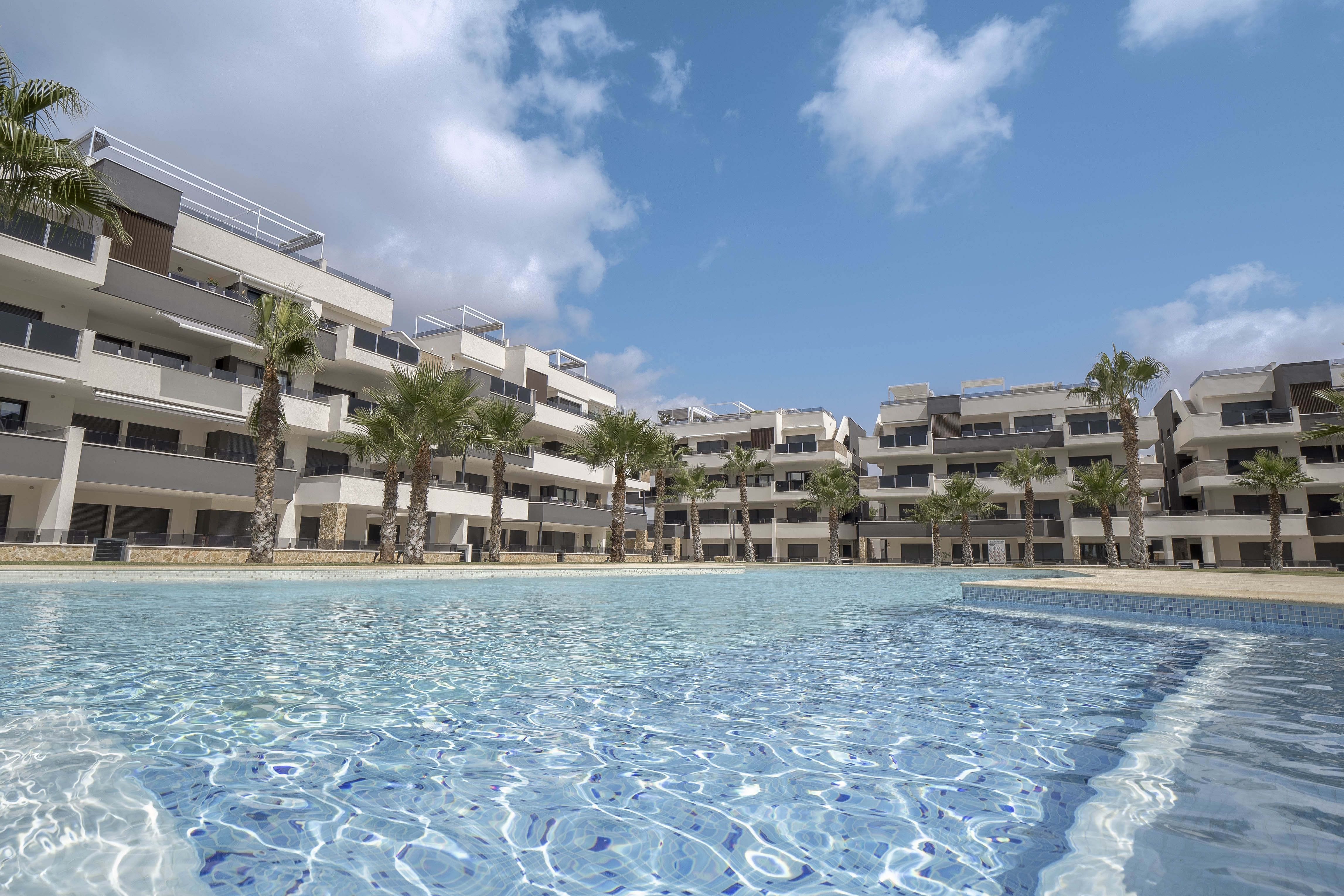 Gemeenschappelijk zwembad met daarachter de appartementenblokken van Amanecer IX, Orihuela Costa, de thuisbasis van Casa Costa Blanca Zuid