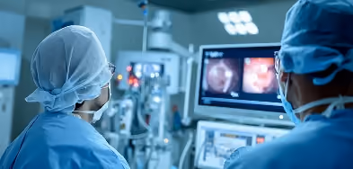 Close-up of a surgical team viewing endoscopic camera footage on monitor screens during a procedure