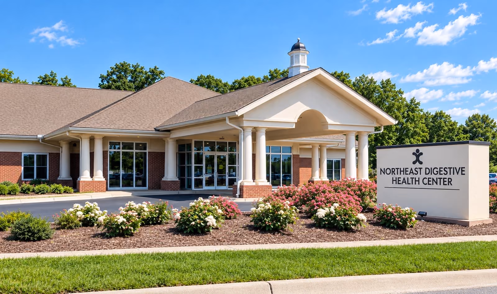 Exterior entrance of Northeast Digestive Health Center at Vinehaven, with a covered portico, landscaped flower beds, and the Cabarrus Gastroenterology Associates building sign