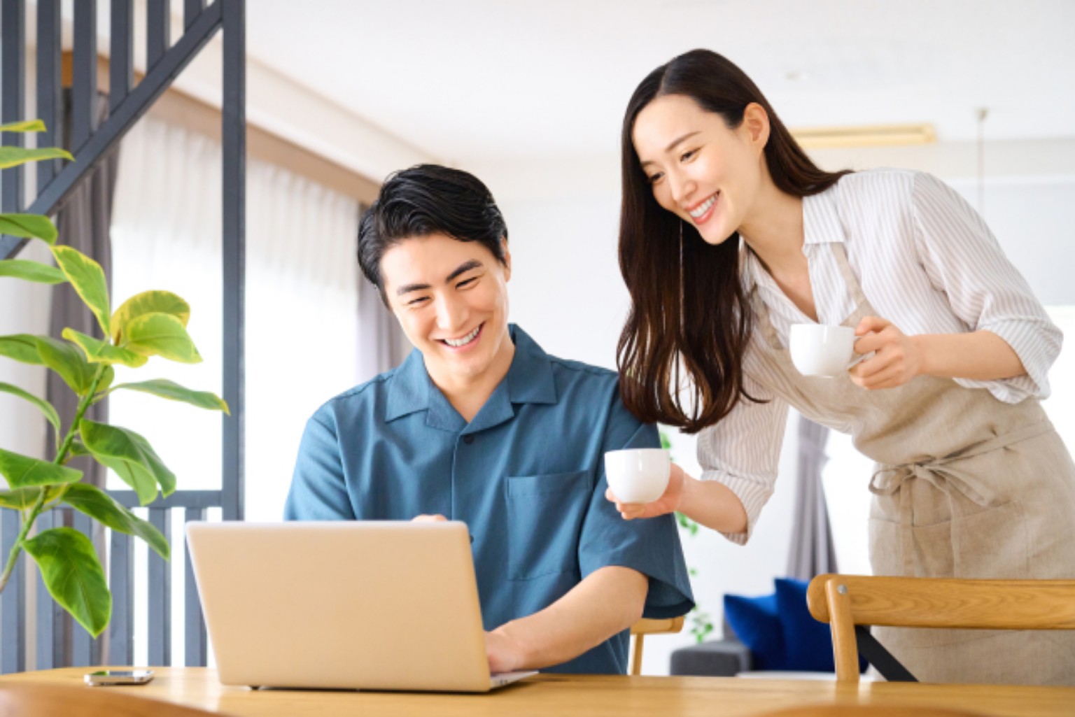自宅でパソコンを見ながら笑顔で話す二人